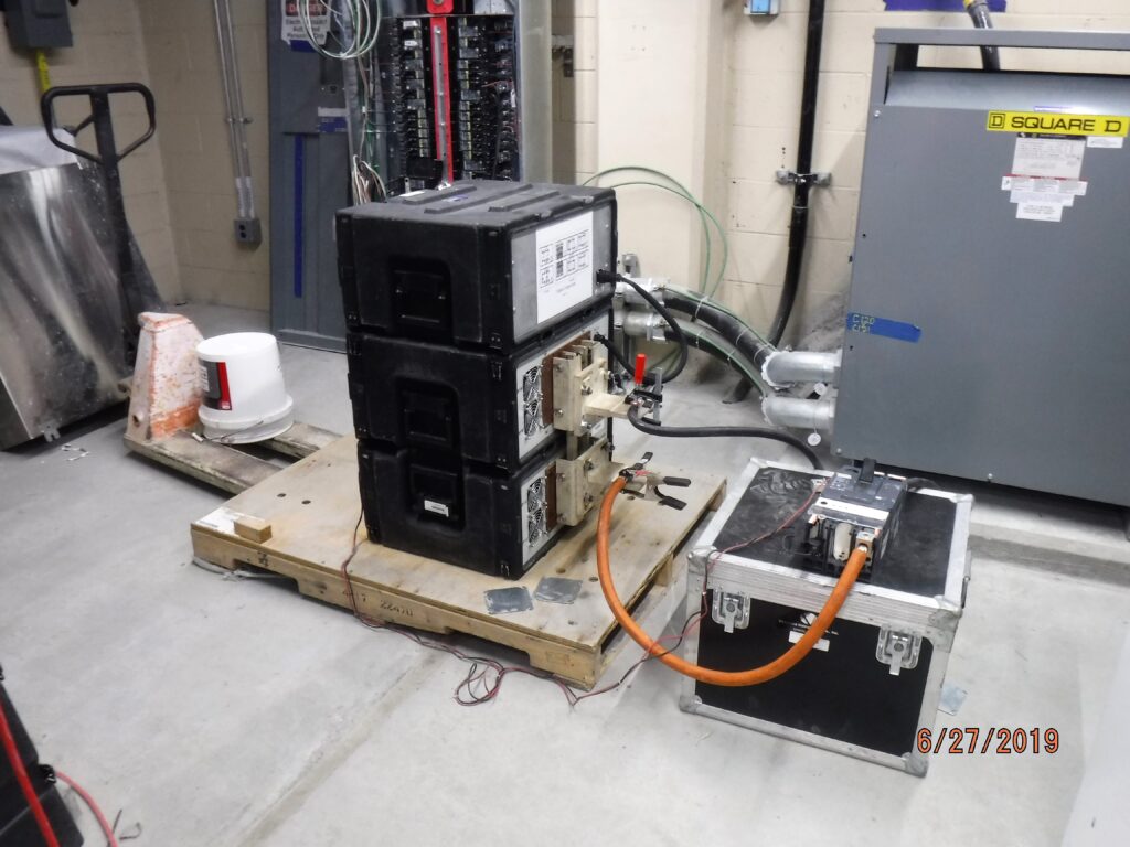 Primary injection test equipment connected to a circuit breaker for protective relay testing