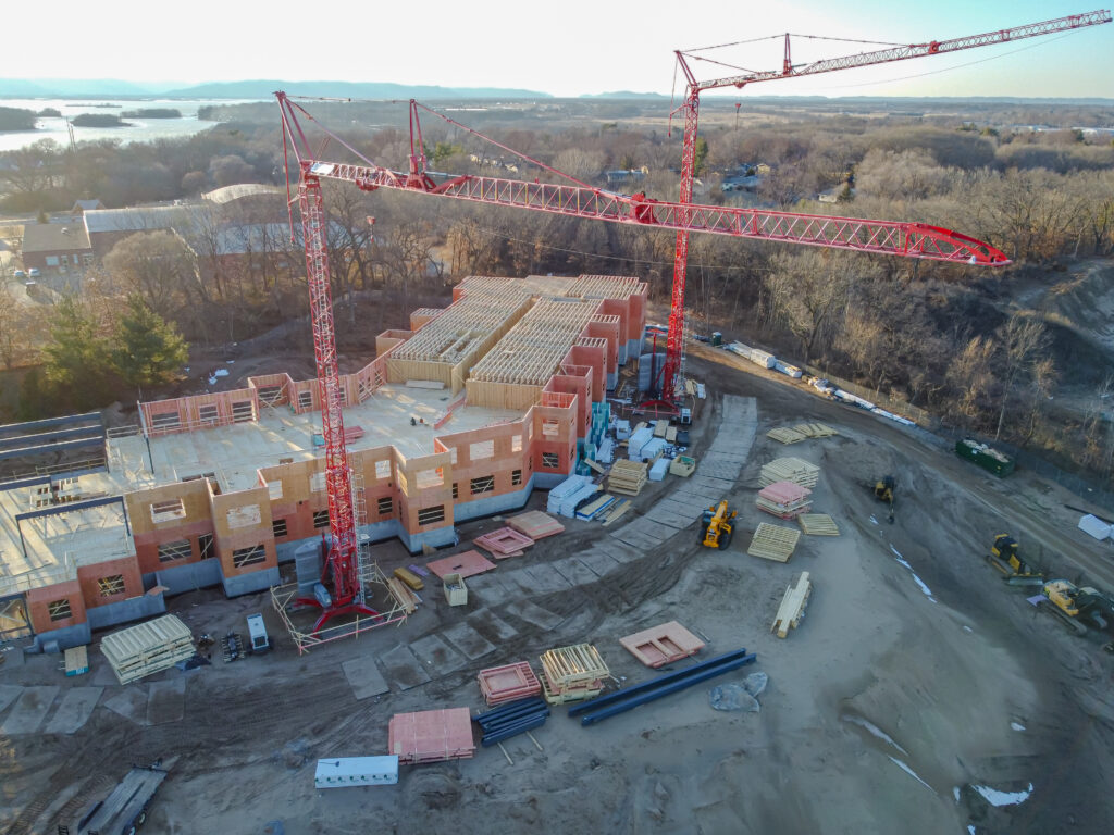 Aerial view of an active infrastructure construction site with tower cranes