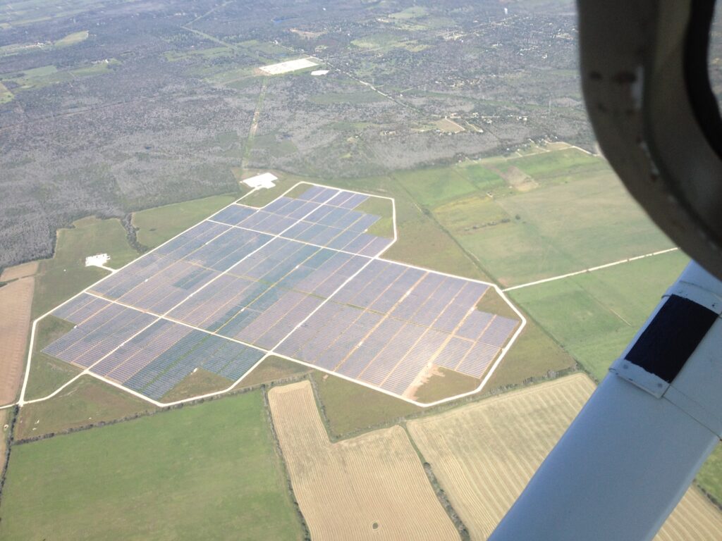 Aerial view of a large solar farm with rows of photovoltaic panels