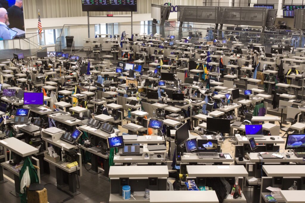 Wide view of a busy financial trading floor with rows of workstations